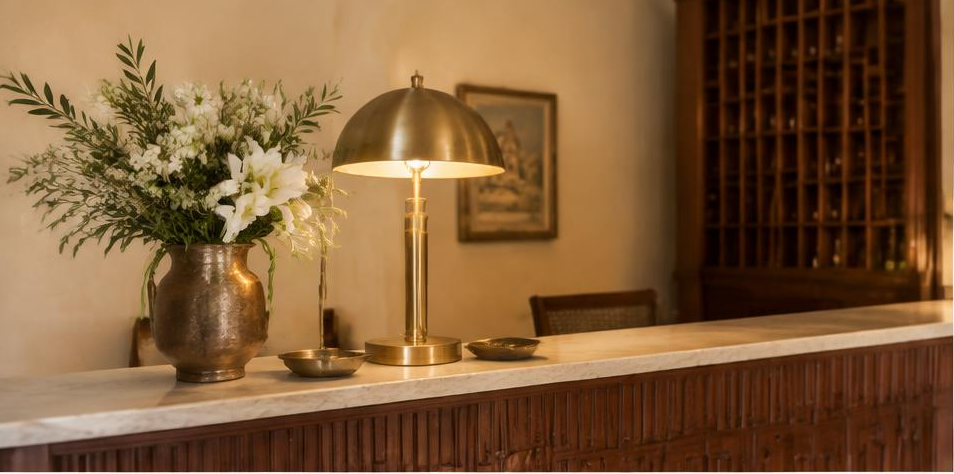 Warm wooden reception desk with flowers and an antique brass lamp